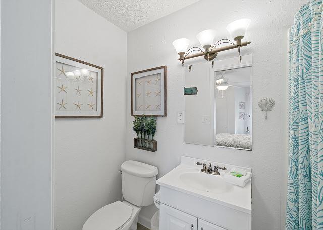1030 East US Highway 98, Unit 203A Destin, FL 32541 - Photo 17 of 35 a bathroom with a toilet a sink and mirror