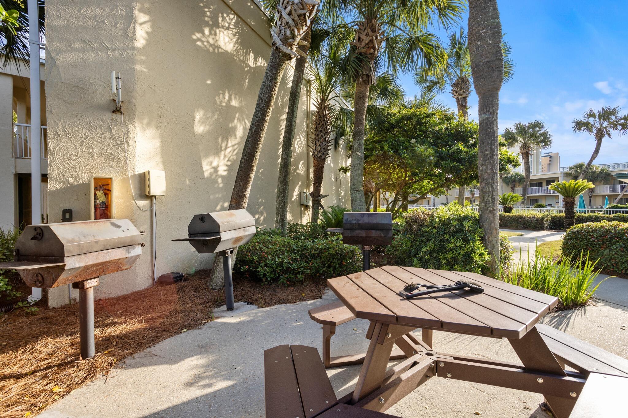 1030 East US Highway 98, Unit 203A Destin, FL 32541 - Photo 29 of 35 a view of a patio with table and chairs potted plants and palm tree