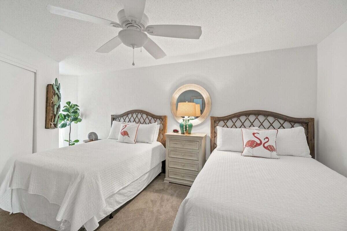 1030 East US Highway 98, Unit 203A Destin, FL 32541 - Photo 7 of 35 a bedroom with bed and a chandelier