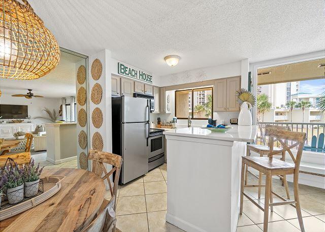 1030 East US Highway 98, Unit 203A Destin, FL 32541 - Photo 8 of 35 a kitchen with stainless steel appliances kitchen island granite countertop a refrigerator and cabinets