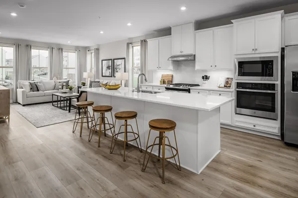 a kitchen with stainless steel appliances granite countertop a stove a sink a microwave a center island and furniture