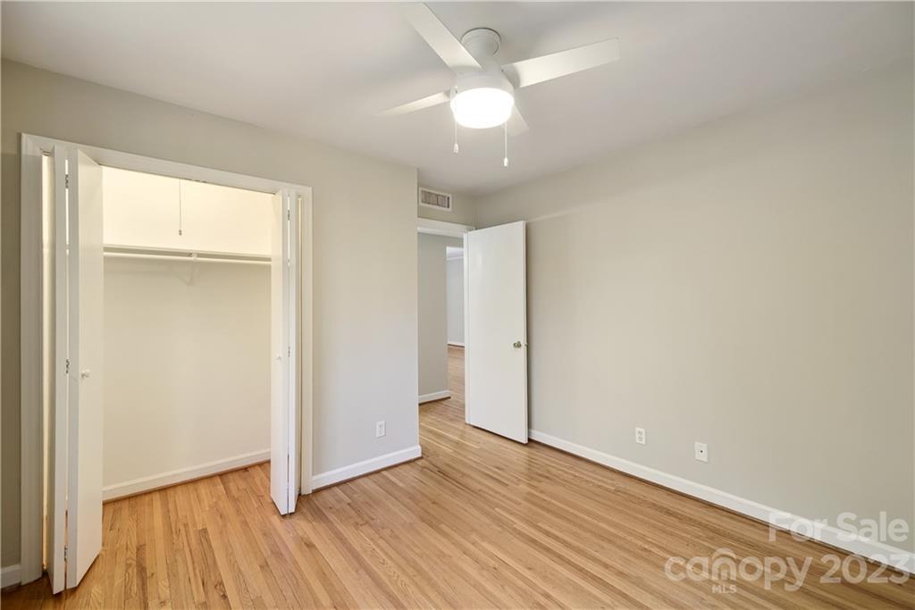 914 McAlway Road Charlotte, NC 28211 - Photo 28 of 44 an empty room with wooden floor and a ceiling fan