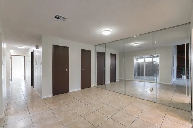 a view of a hallway with wooden cabinets