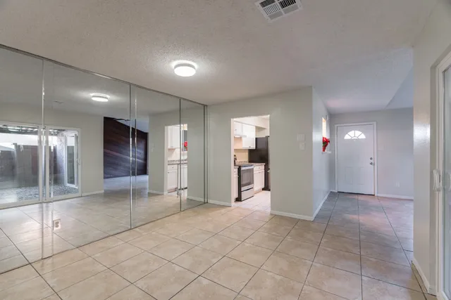 a view of a hallway with wooden cabinets