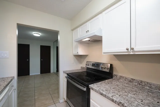a kitchen with granite countertop a stove and a sink