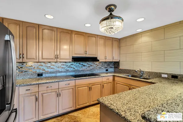 a kitchen with granite countertop a sink a stove and cabinets