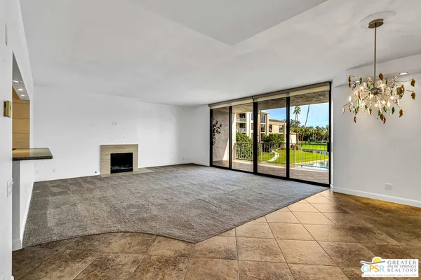 a view of an empty room with window chandelier and front door