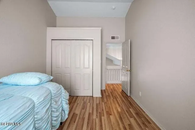 a bedroom with a bed and wooden floor