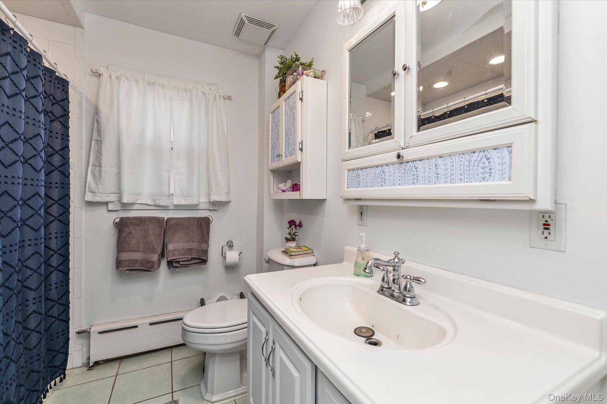 81 Stuart Street Lynbrook, NY 11563 - Photo 12 of 23 a bathroom with a sink a toilet and shower