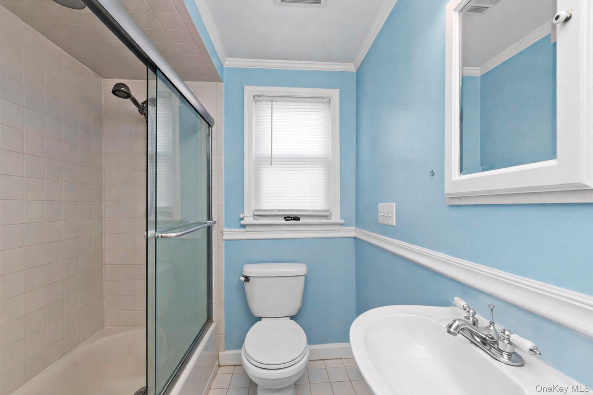 81 Stuart Street Lynbrook, NY 11563 - Photo 19 of 23 a bathroom with a toilet a sink and a bathtub