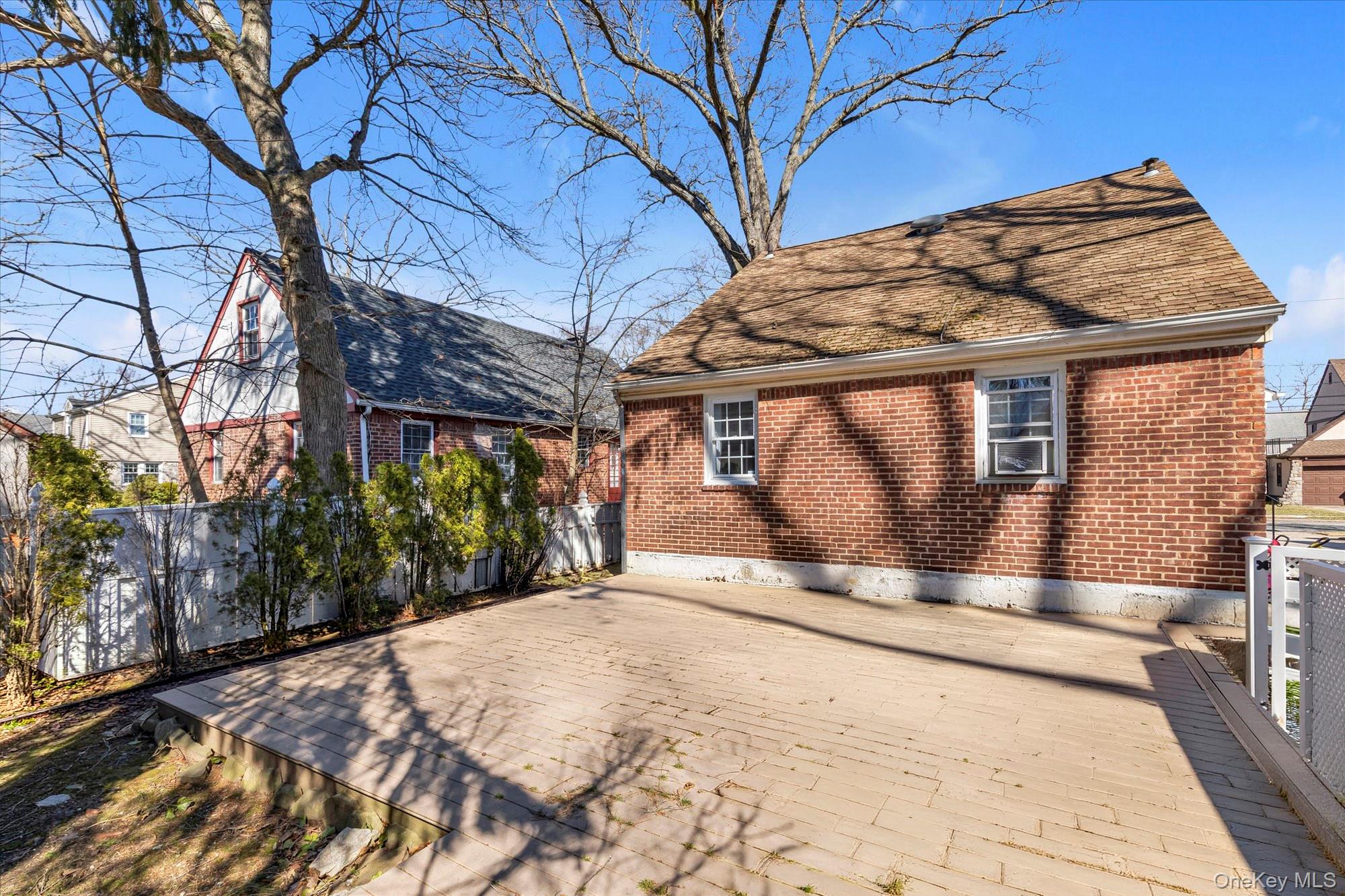 81 Stuart Street Lynbrook, NY 11563 - Photo 20 of 23 a view of a backyard with a large tree
