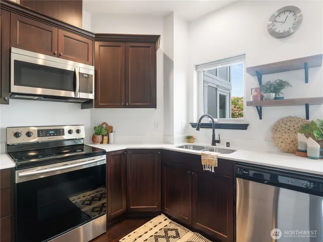 a kitchen with stainless steel appliances a stove a sink and a microwave