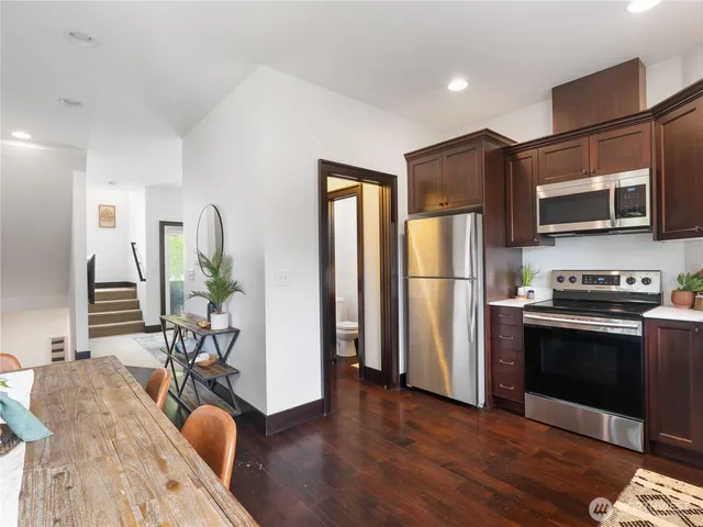 a kitchen with stainless steel appliances granite countertop a refrigerator stove microwave and cabinets