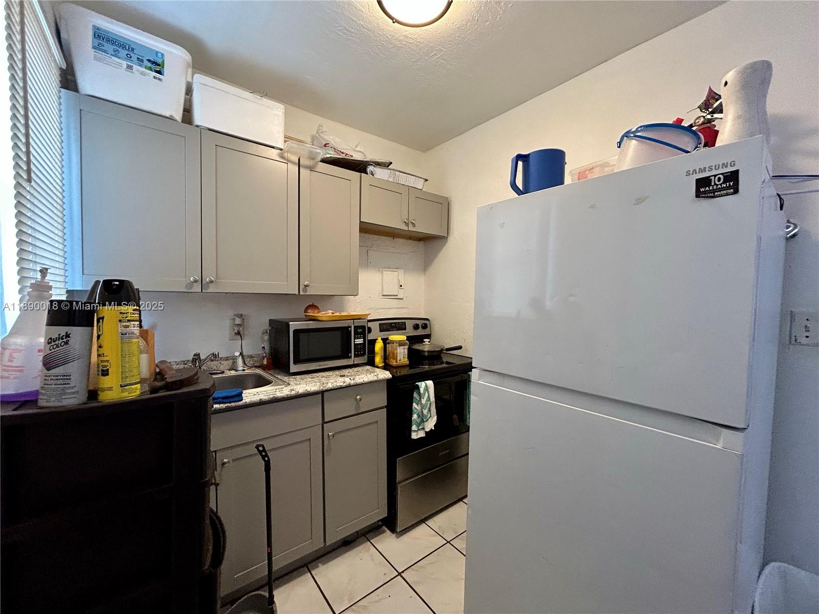 2013 Washington Avenue Opa-Locka, FL 33054 - Photo 11 of 19 a kitchen with a refrigerator and white cabinets
