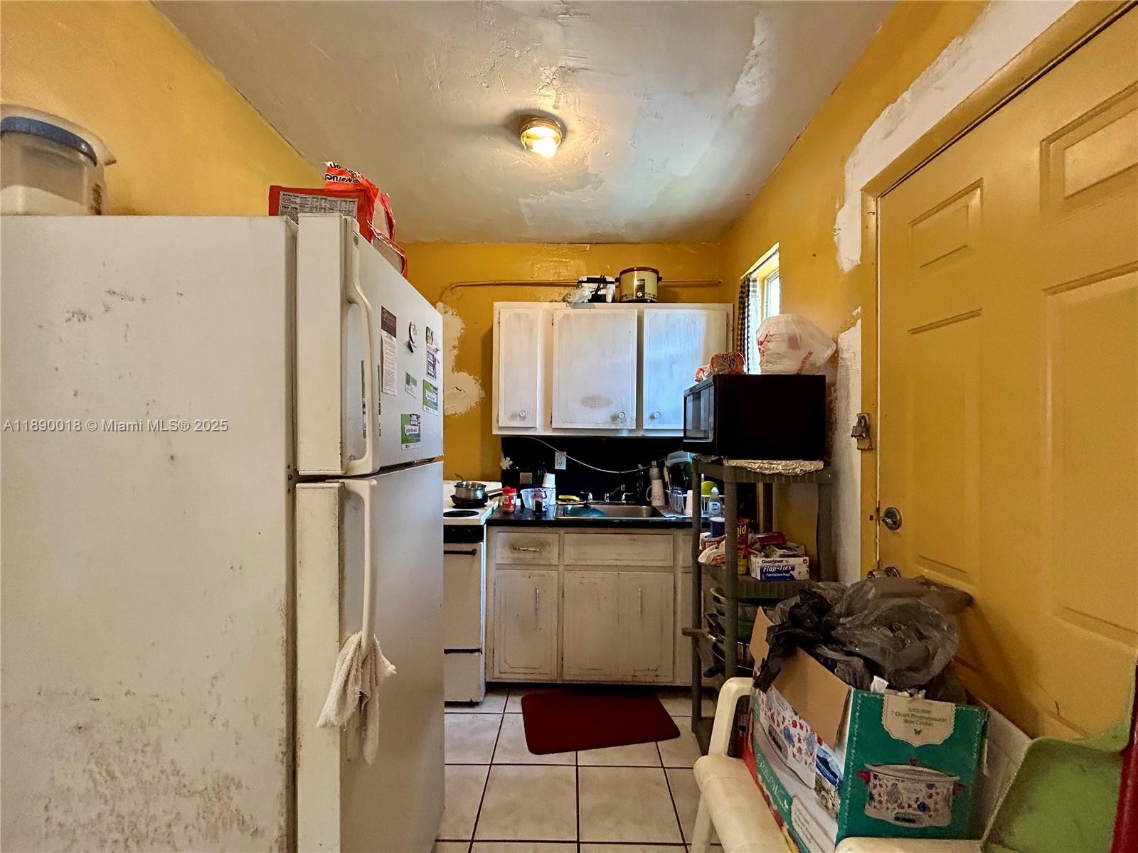 2013 Washington Avenue Opa-Locka, FL 33054 - Photo 16 of 19 a kitchen with a refrigerator and a stove top open