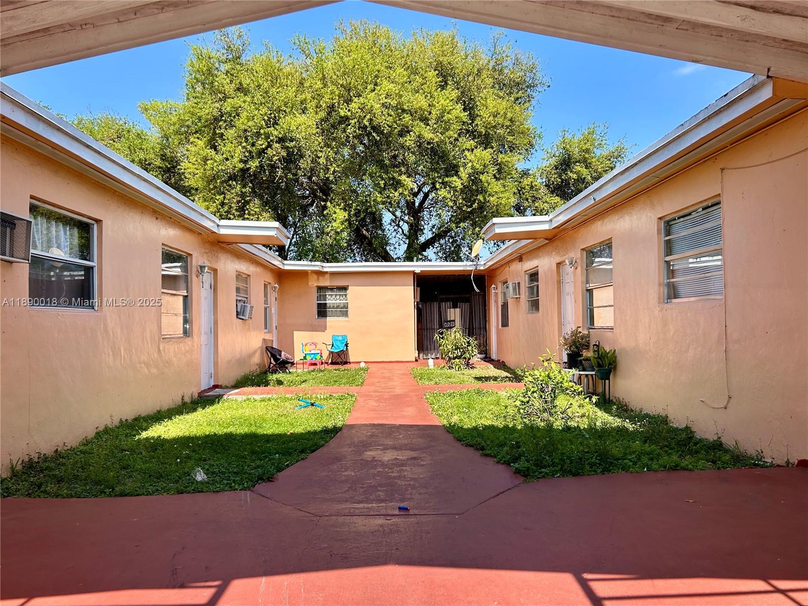 2013 Washington Avenue Opa-Locka, FL 33054 - Photo 5 of 19 a front view of a house with a yard and potted plants