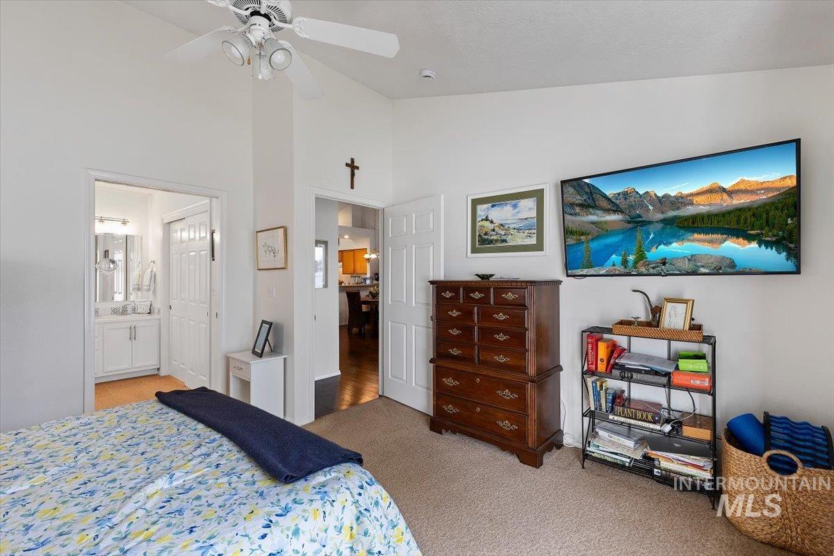 3357 West Fieldstream Lane Meridian, ID 83646 - Photo 16 of 24 Bedroom featuring light colored carpet, vaulted ceiling, a ceiling fan, and ensuite bathroom