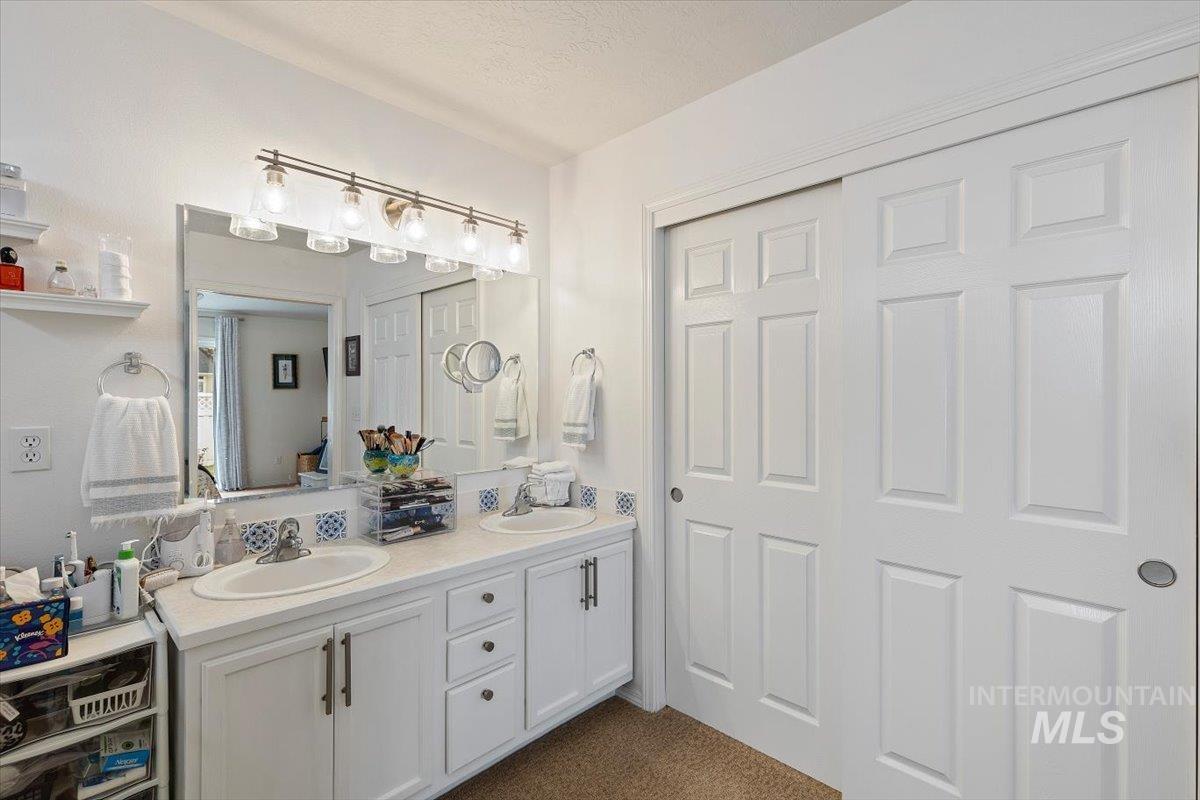3357 West Fieldstream Lane Meridian, ID 83646 - Photo 18 of 24 Bathroom with double vanity and dark colored carpet