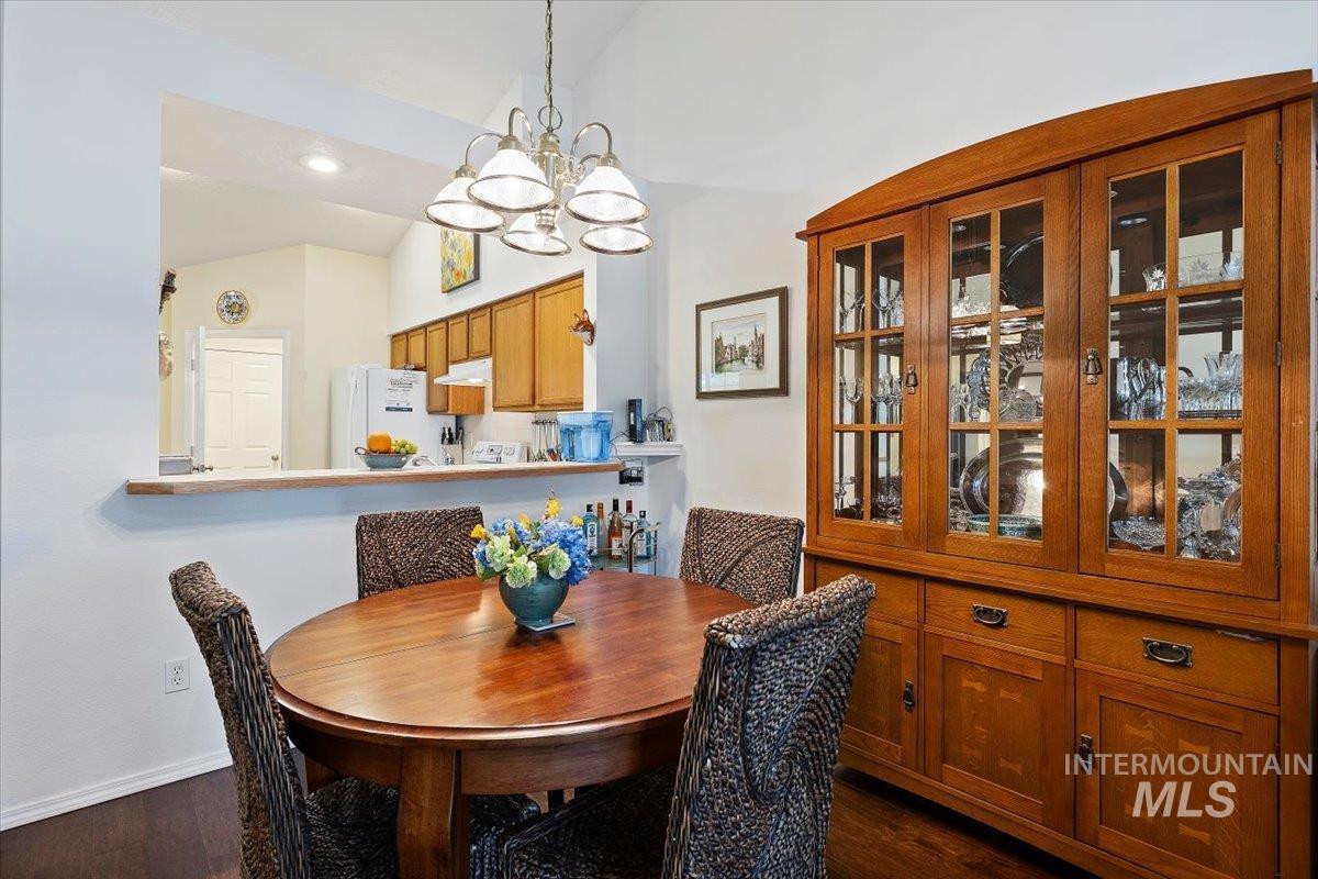3357 West Fieldstream Lane Meridian, ID 83646 - Photo 9 of 24 Dining area with suspended lighting, vaulted ceiling, and dark wood-style flooring