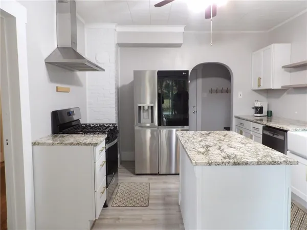 a kitchen with stainless steel appliances granite countertop a sink stove and refrigerator