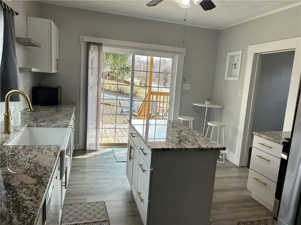 a kitchen with granite countertop a sink appliances and cabinets