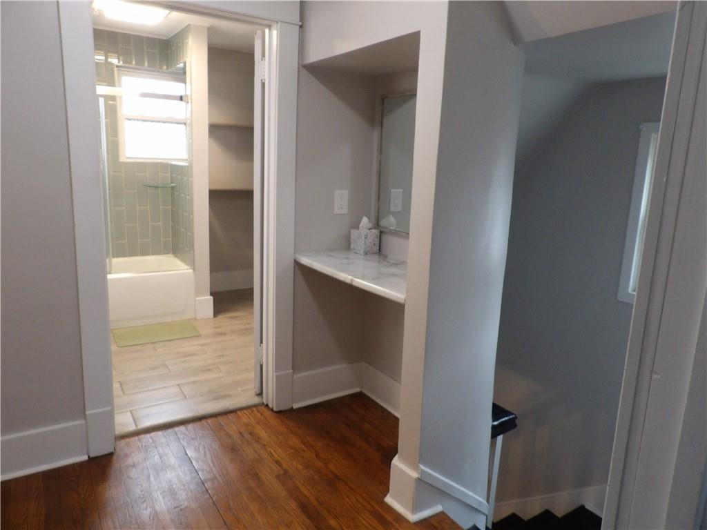 230 Maple Street Everson, PA 15631 - Photo 27 of 32 an empty room with wooden floor and a bathroom