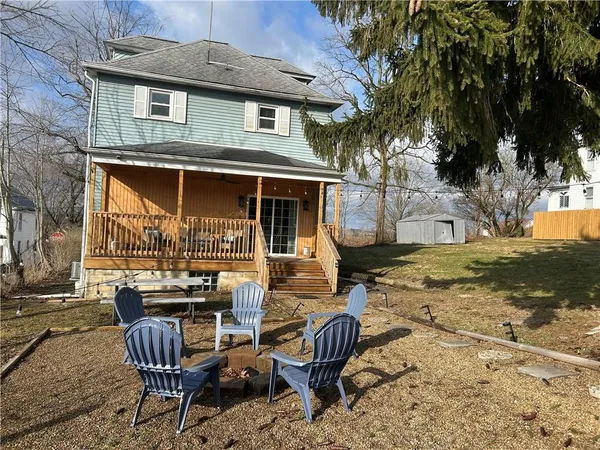 a view of a house with backyard and sitting area