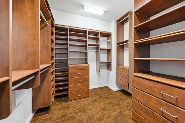 a view of walk in closet with clothes and shoes