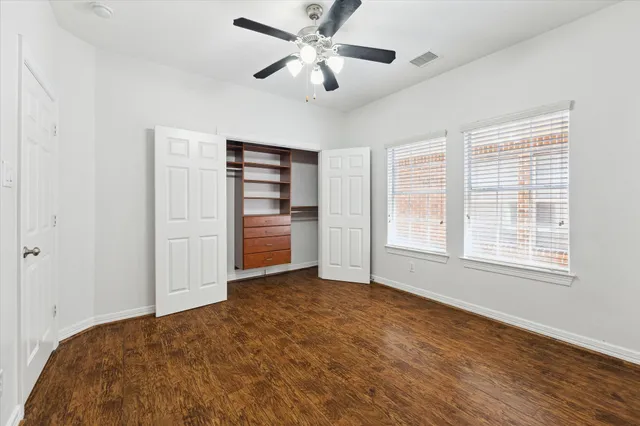 a view of an empty room with a window and a kitchen