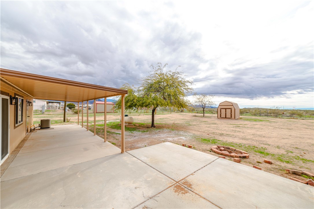 3248 West Carmichael Road Golden Valley, AZ 86413 - Photo 47 of 53 View of patio / terrace featuring a shed and an outdoor fire pit