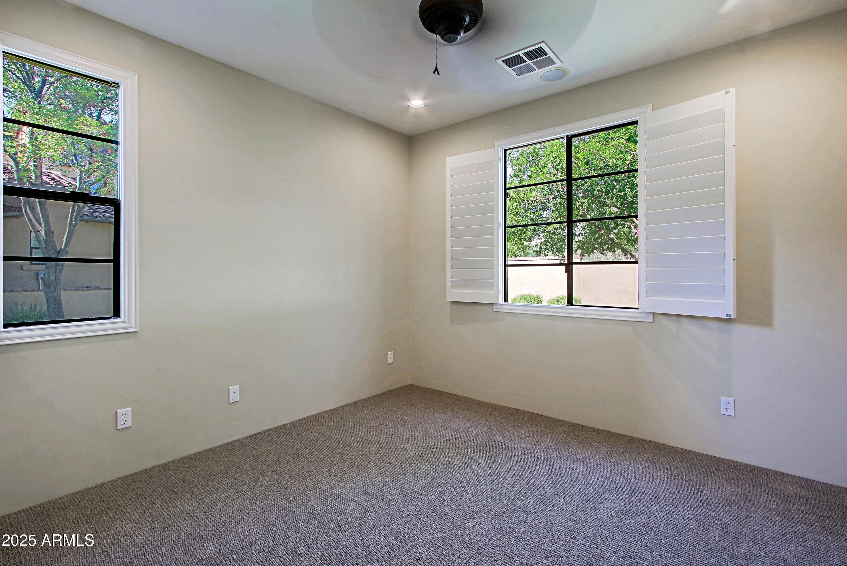 18650 North Thompson Peak Parkway, Unit 1052 Scottsdale, AZ 85255 - Photo 22 of 38 an empty room with windows and ceiling fan