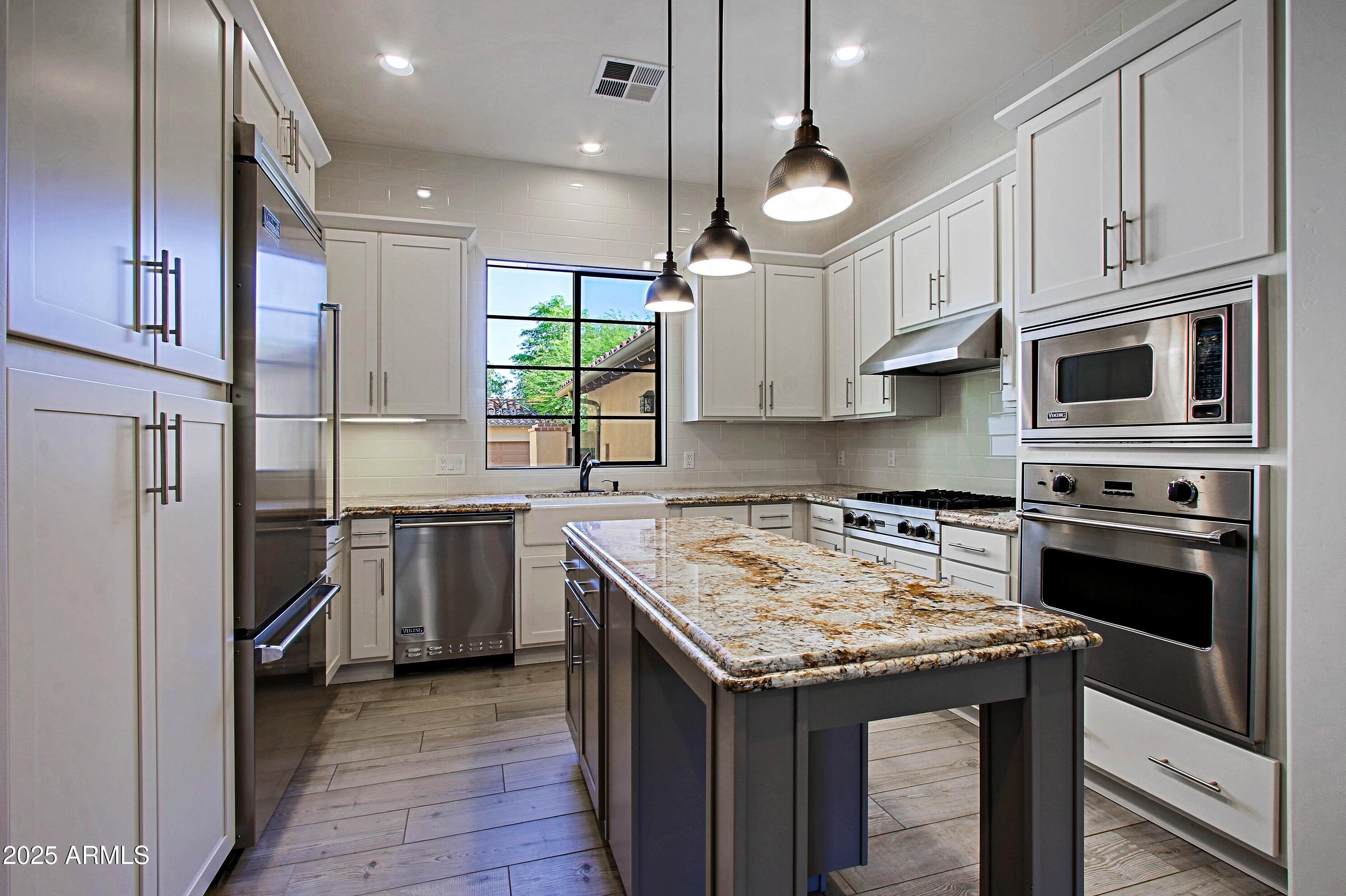 18650 North Thompson Peak Parkway, Unit 1052 Scottsdale, AZ 85255 - Photo 3 of 38 a kitchen with stainless steel appliances granite countertop a kitchen island a stove a sink and a refrigerator