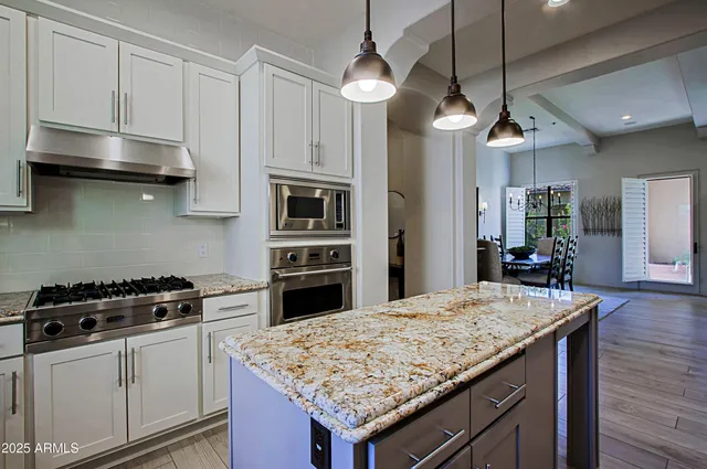a kitchen with granite countertop a sink a counter space appliances and cabinets