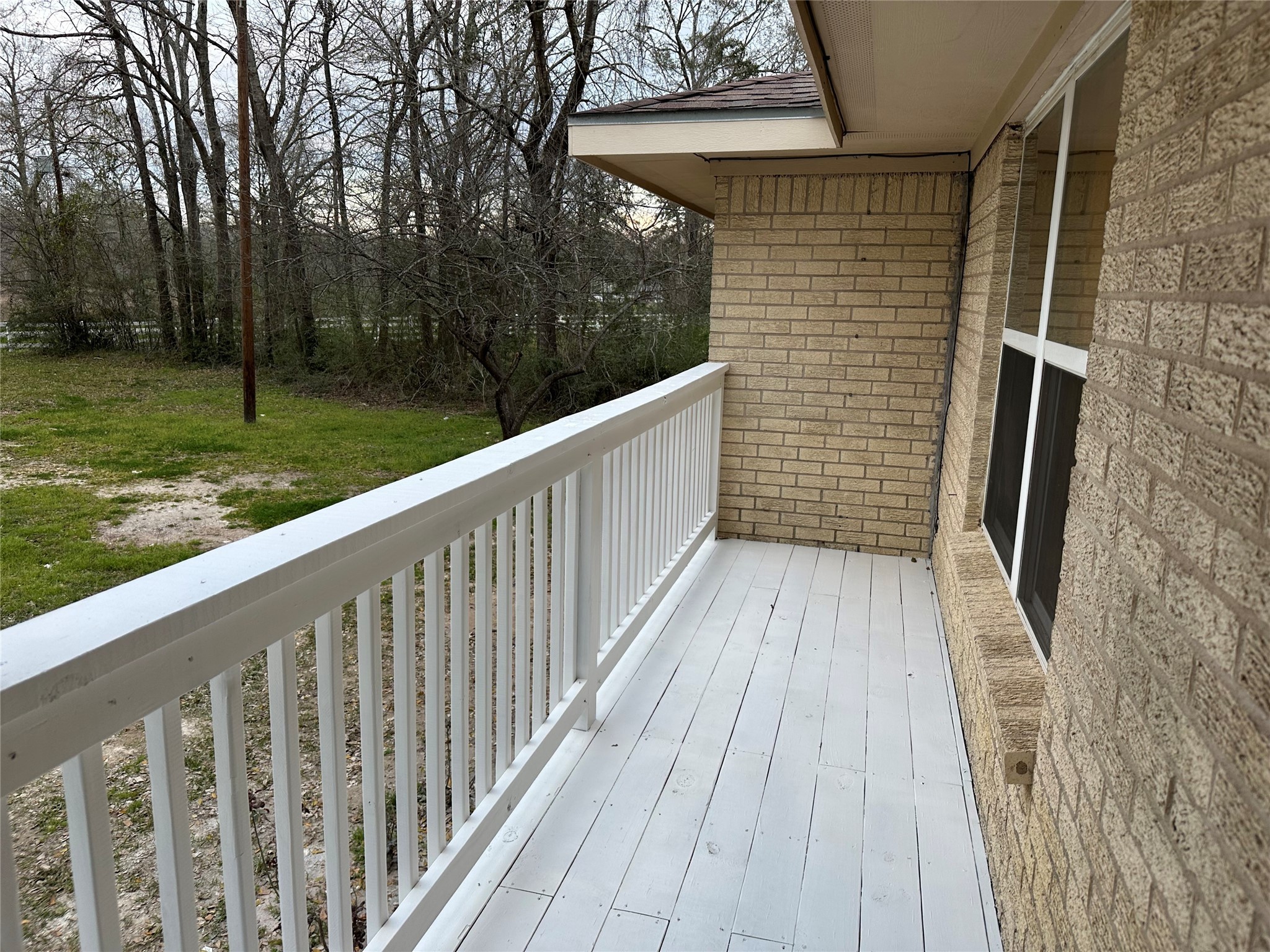 10412 Ehlers Road Conroe, TX 77302 - Photo 3 of 18 a view of a balcony with wooden floor and fence