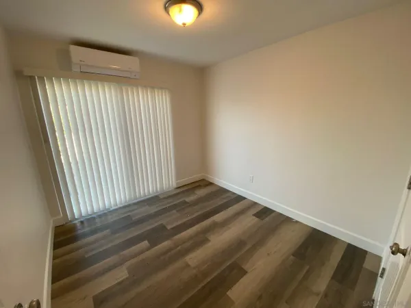 a view of a room with wooden floor and a window