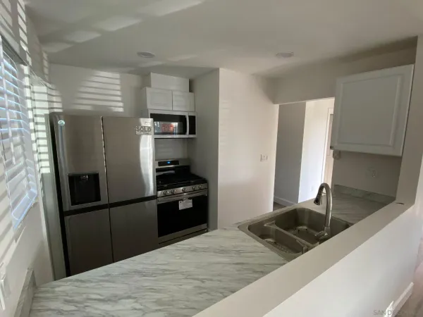 a kitchen with stainless steel appliances granite countertop a refrigerator and a sink