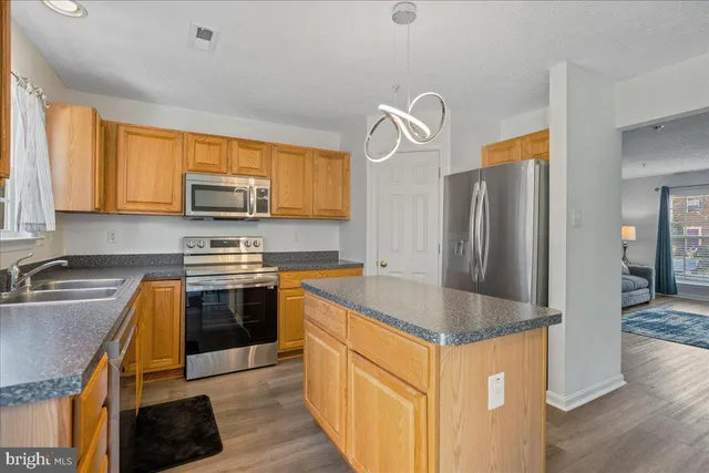 a kitchen with stainless steel appliances granite countertop a sink a stove and cabinets