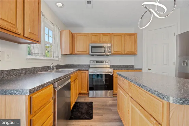 a kitchen with a refrigerator and wooden floor