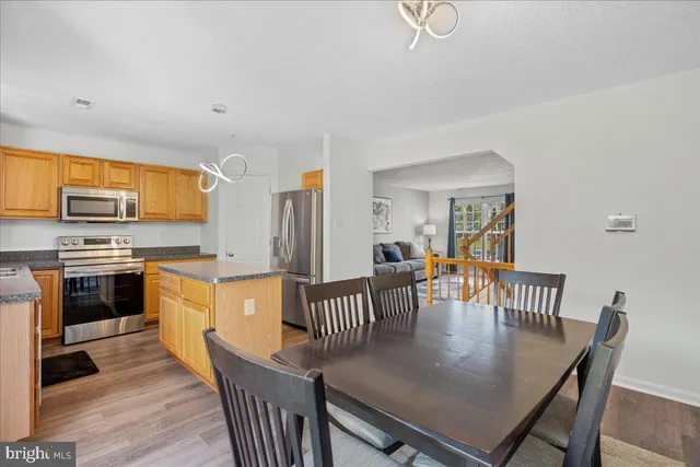 a kitchen with stainless steel appliances granite countertop a kitchen island a stove a table and chairs