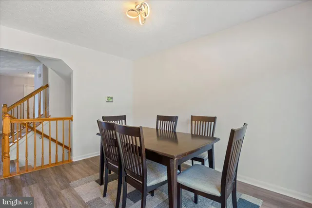 a view of a dining room with furniture a rug and wooden floor