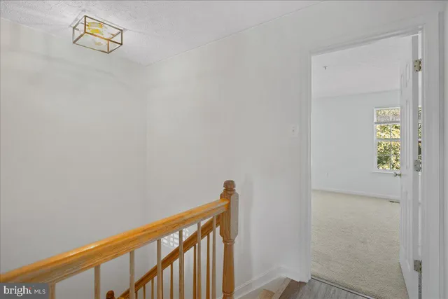 a view of a hallway with wooden floor and stairs