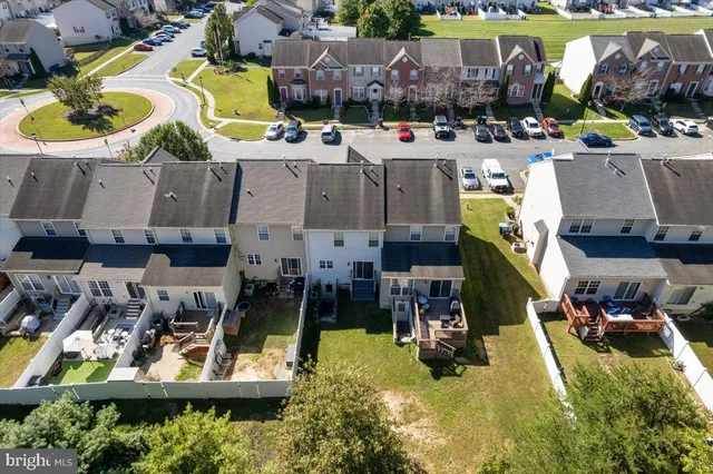 an aerial view of residential houses with outdoor space and trees