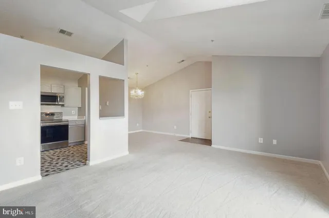 a view of a kitchen with refrigerator and a sink