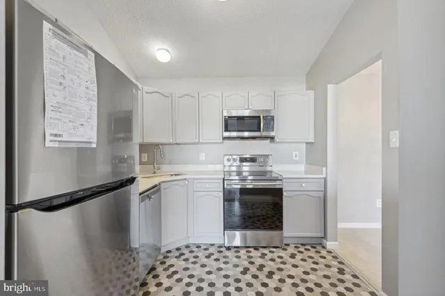 a kitchen with stainless steel appliances granite countertop a refrigerator sink and stove