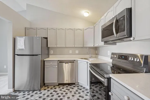 a kitchen with stainless steel appliances granite countertop a refrigerator sink and stove