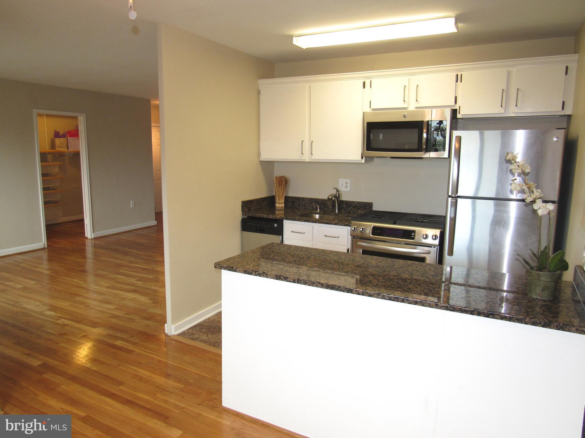 1300 South Arlington Ridge Road, Unit 617 Arlington, VA 22202 - Photo 9 of 25 a kitchen with kitchen island a counter top space cabinets and stainless steel appliances