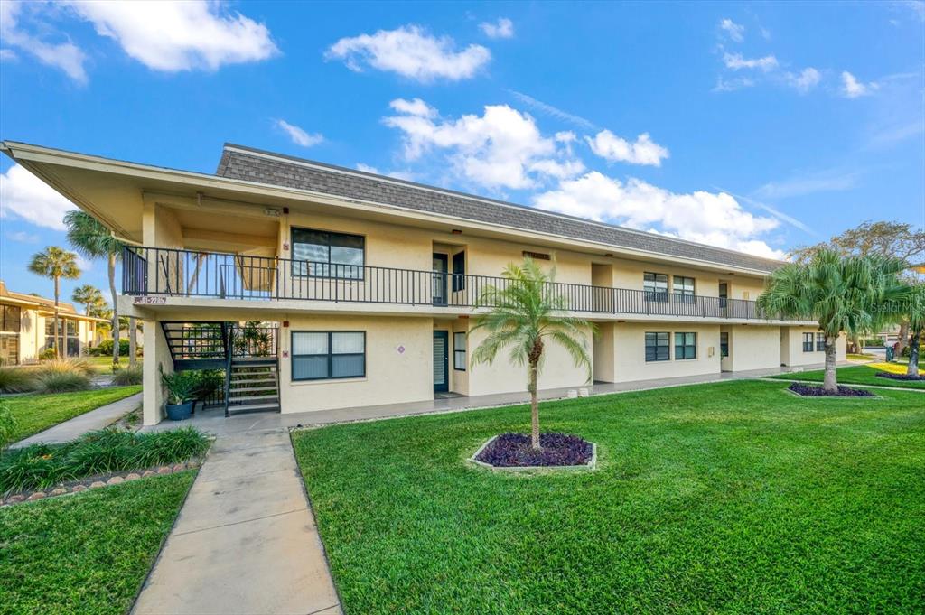 12300 Vonn Road, Unit 2202 Largo, FL 33774 - Photo 1 of 1 a front view of a house with a yard and potted plants