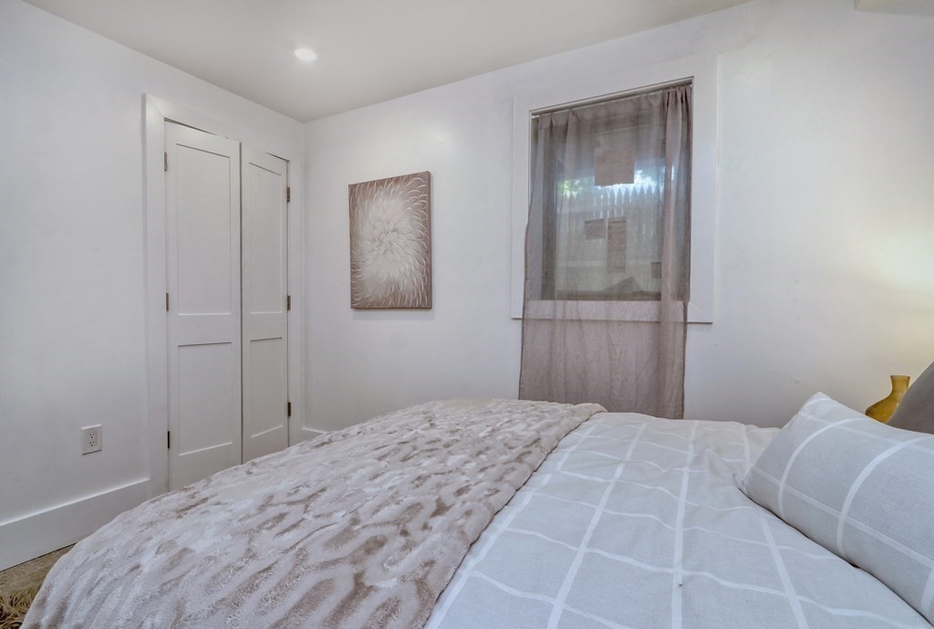 4 Everett Place, Unit 1 Boston, MA 02128 - Photo 16 of 19 a bedroom with a bed and a mirror