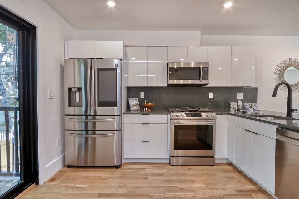 4 Everett Place, Unit 1 Boston, MA 02128 - Photo 9 of 19 a kitchen with stainless steel appliances a refrigerator sink and microwave