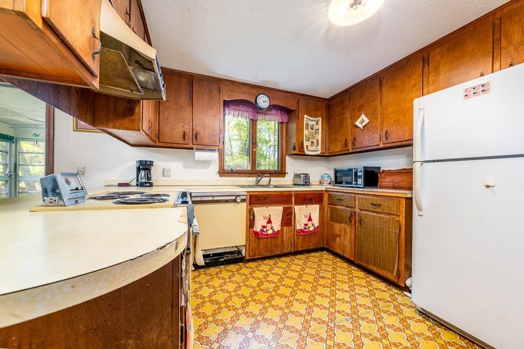 231 Monomoy Circle Barnstable, MA 02632 - Photo 13 of 28 a kitchen with granite countertop a refrigerator a stove a sink and cabinets